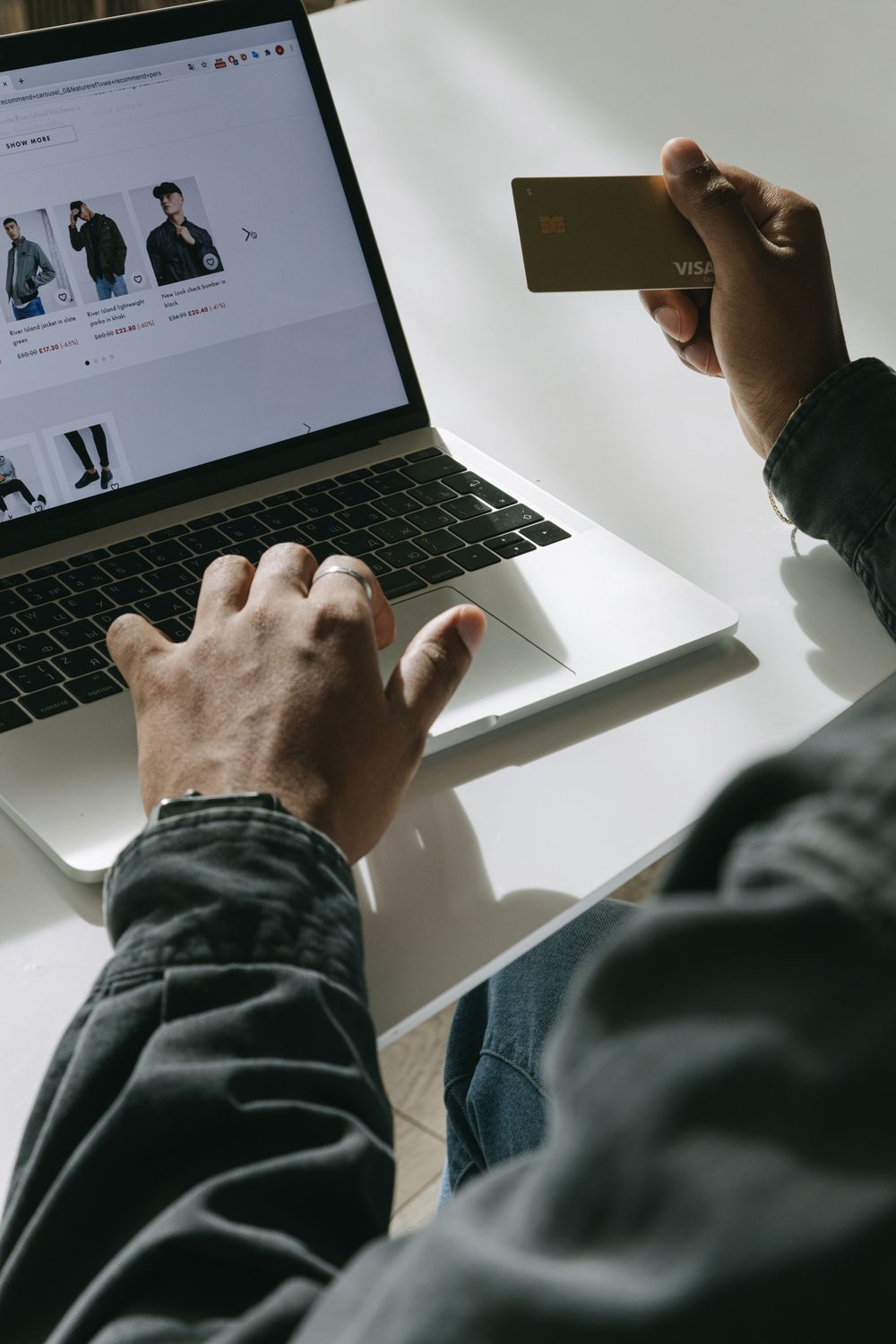 A customer using a laptop and card for an online purchase