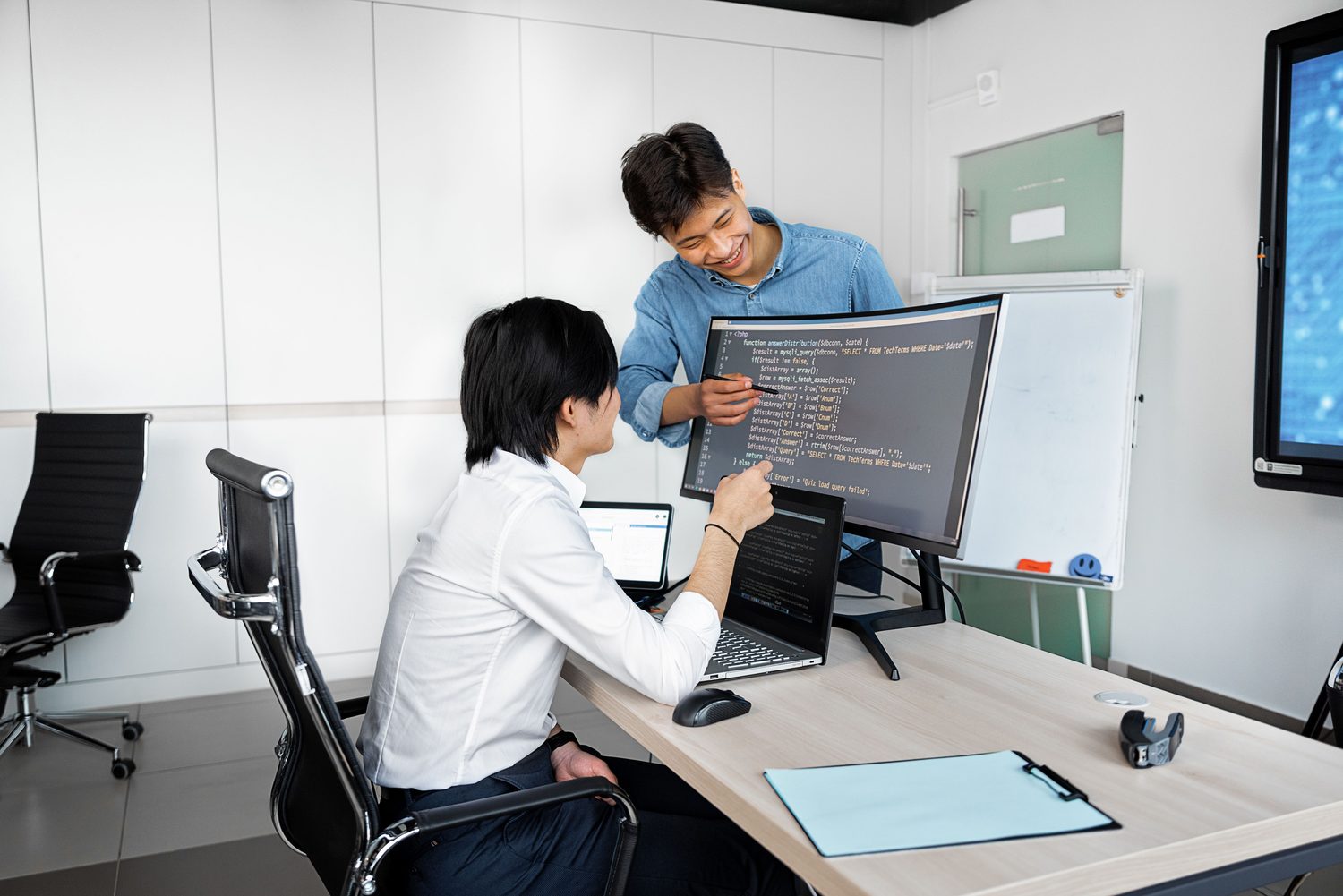 Two software professionals reviewing code together