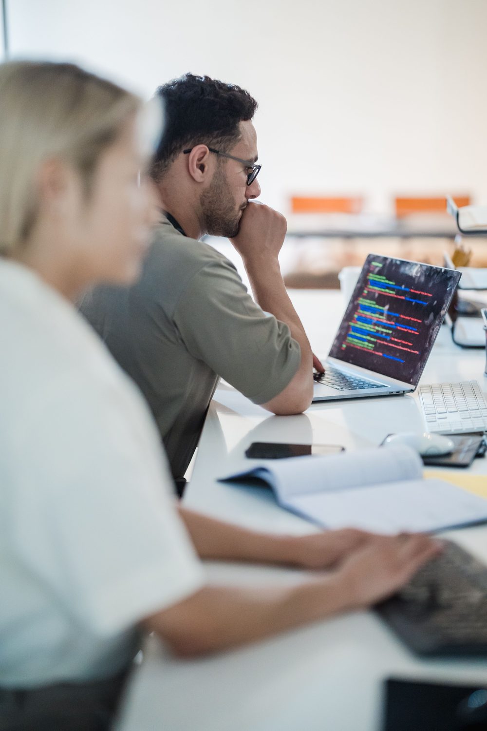 Software professionals working with code on a laptop